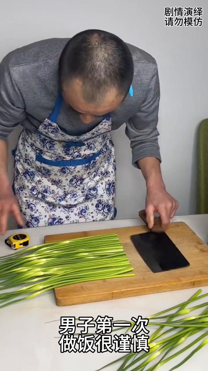 男子第一次做饭用米尺测量蒜薹长度，这一幕真的太有才了。
男子第一次做饭很谨慎，只