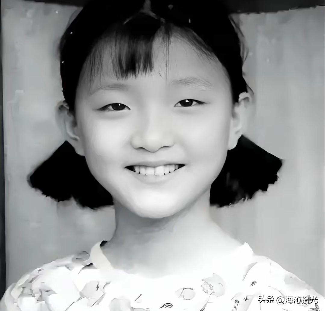 这张照片上的小女孩笑容灿烂，满脸童真。
大家一眼能看出她是谁吗？
真是女大十八变