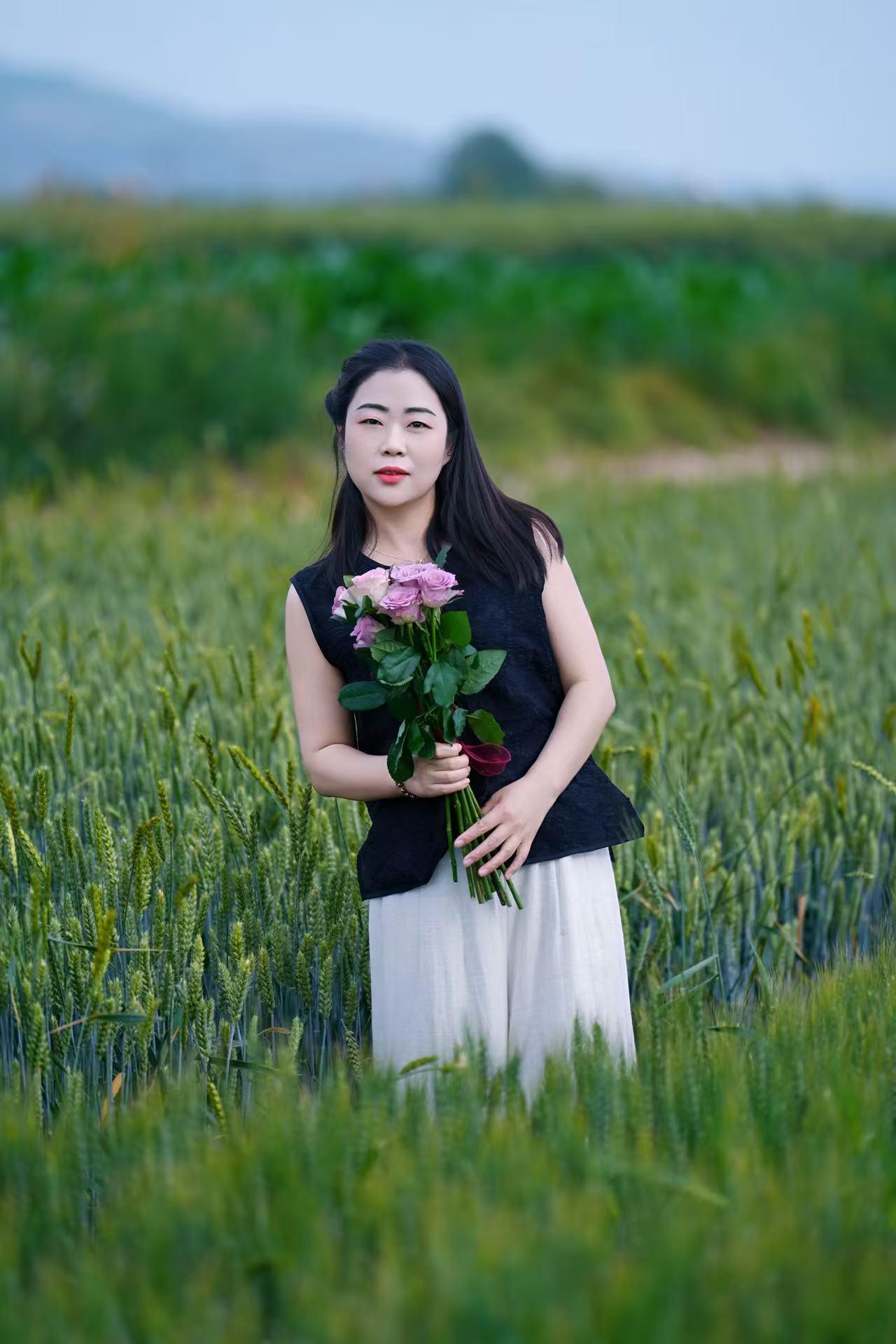 一个女孩在田野里拿着花。
