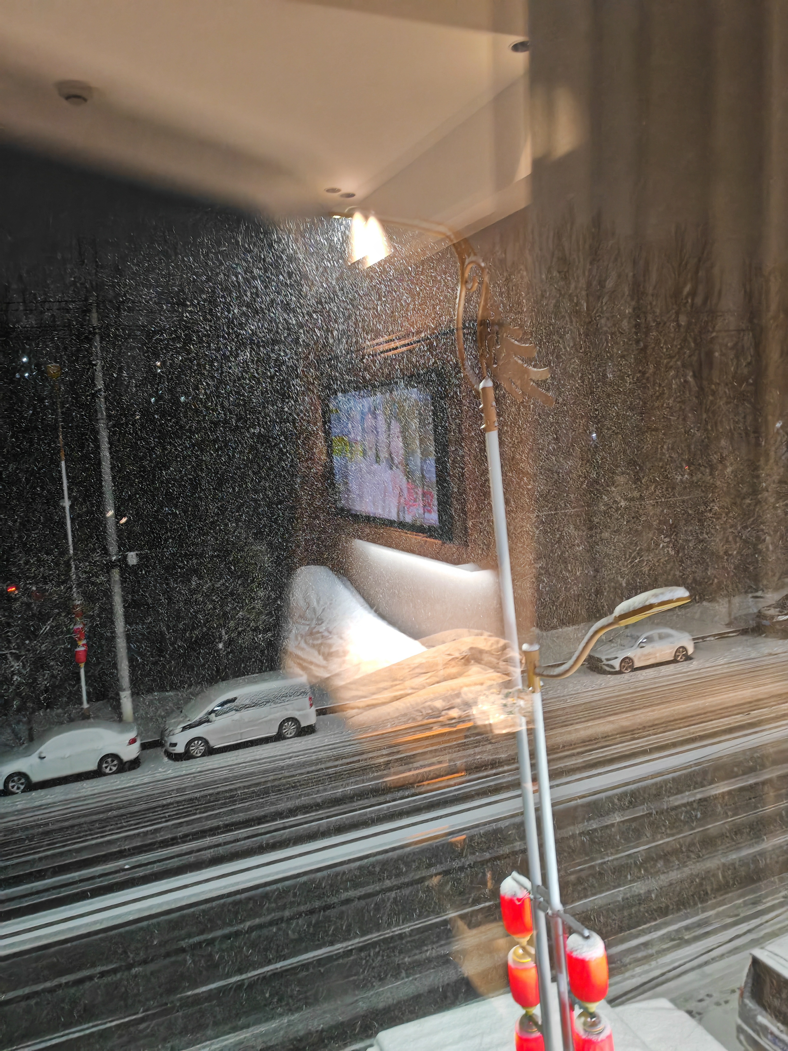 灯光下的雪显得格外的漂亮，透过窗拍照，仿佛屋里也下起了大雪，这种氛围感觉还挺浪漫