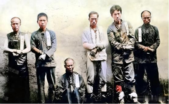 1911年4月，广州，临行前的黄花岗革命志士。他们赤着双脚，戴着手铐与脚镣。站着