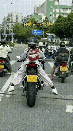 姑娘个不高，骑个大摩托，路口遇红灯，双肩够不着。左右乱摇晃，磨坏裤中央！