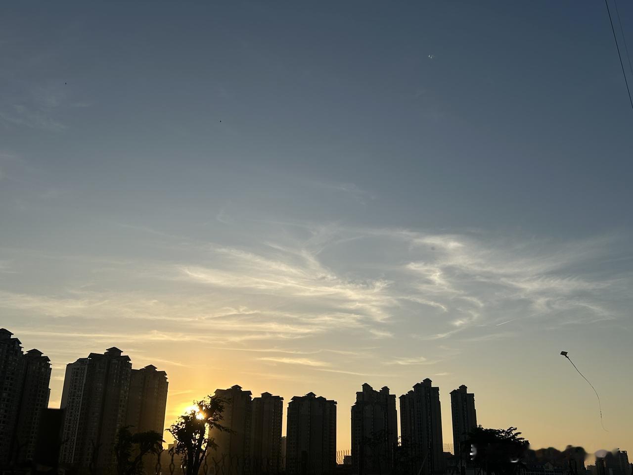 中午2点的太阳晒得身上黏糊糊的，风静了下来。我眯着眼睛，抽着烟，体会着皮肤被晒的