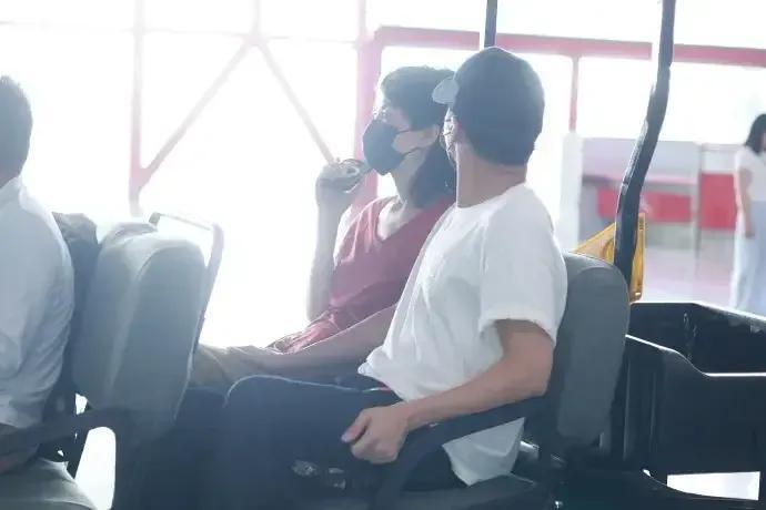 王菲、谢霆锋低调现身北京机场，两人戴着黑色口罩，谢霆锋白色和王菲红色上衣情侣装很