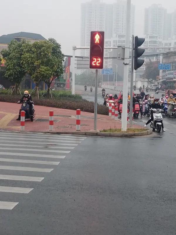今早，我骑着电动车路过一个路口，看到红灯亮起，便自觉停了下来。
       身