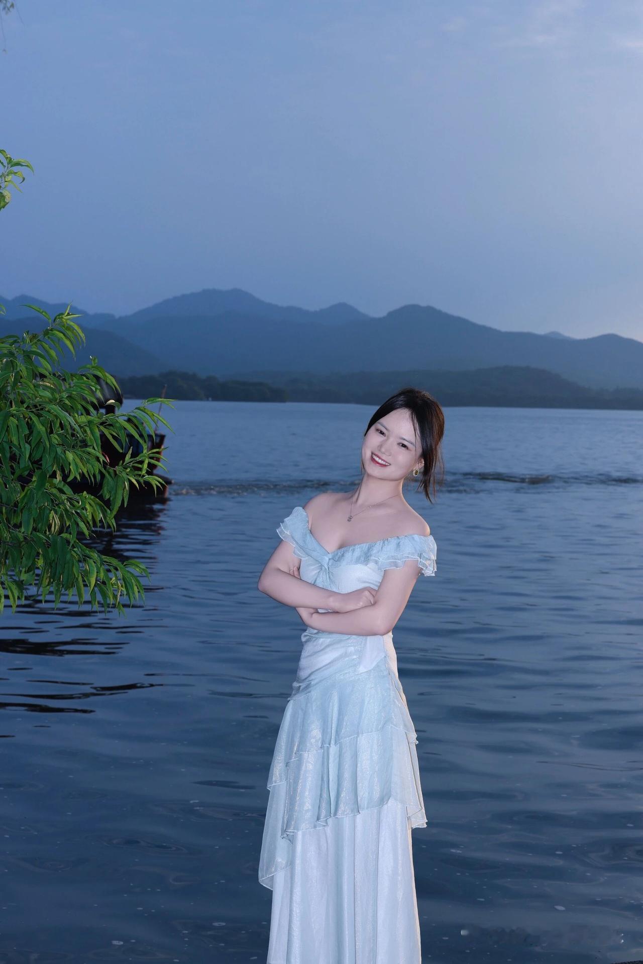 一个女孩站在湖边微笑。