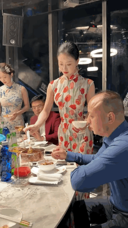 重庆君宴·云端火锅看江景，年轻漂亮旗袍小姐姐给顾客分菜，贴心的服务，展示中国元素