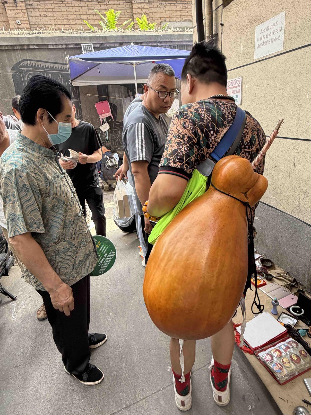 今无上午，我逛西安档子，在西仓南巷，看到一位老帅哥背着个大葫芦，引来众多人的目光