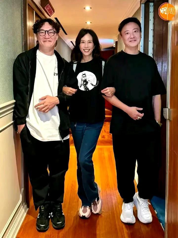 莫文蔚手挽两个帅哥，右手边的是著名歌手陈奕迅，尤其是他的一首孤勇者，成为小朋友心