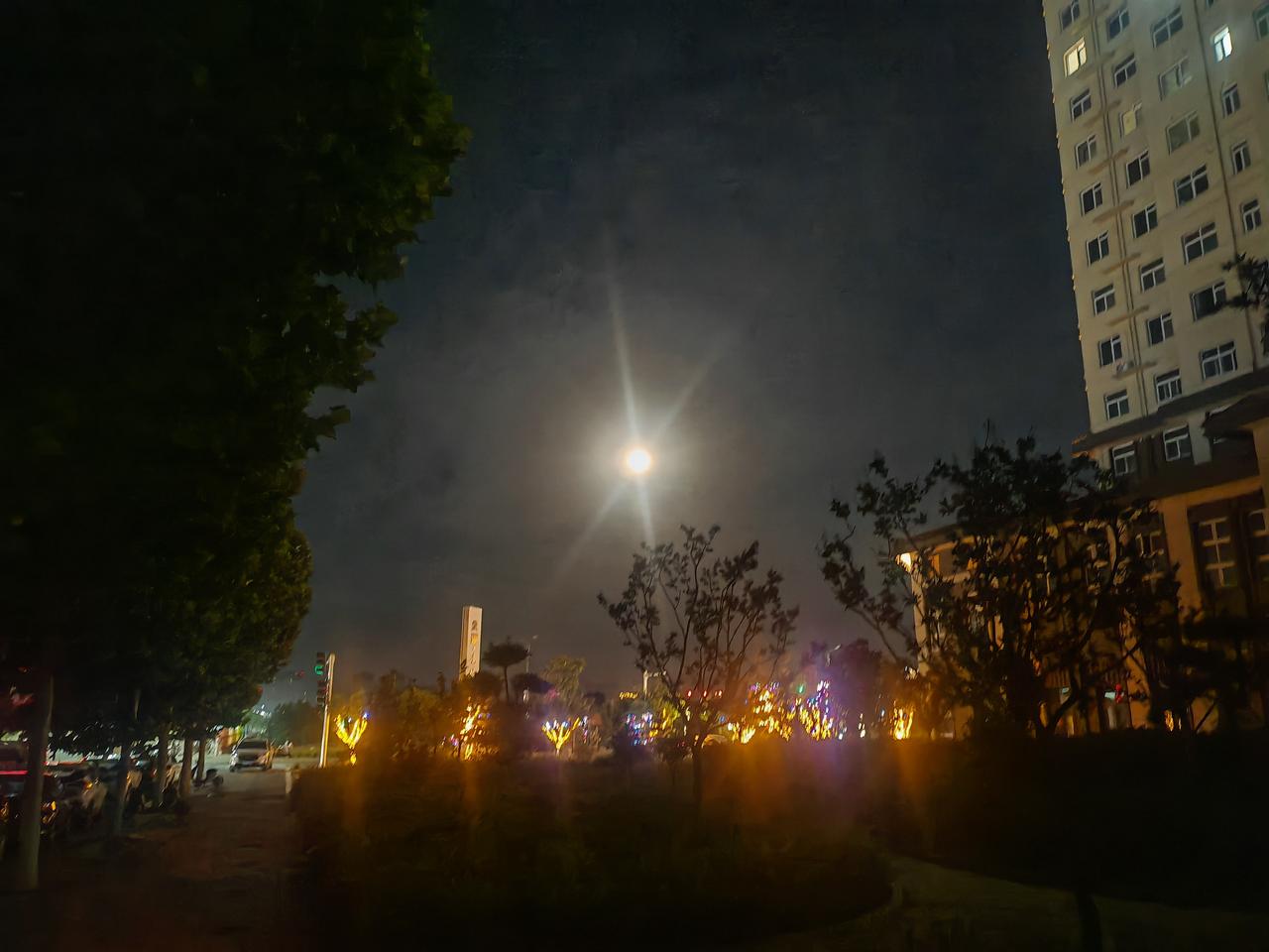 分享你手机相册里的一张天空照这是一幅夜晚街景。夜空中一轮圆月高悬，清辉洒落，带着