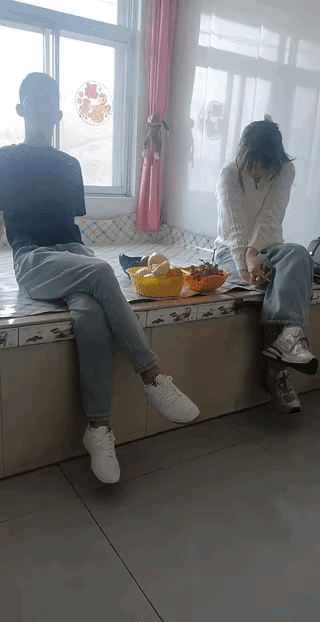 农村青年男女相亲，女孩相貌清秀，打扮时尚，低着头摆弄的双手，看着手机很害羞的样子