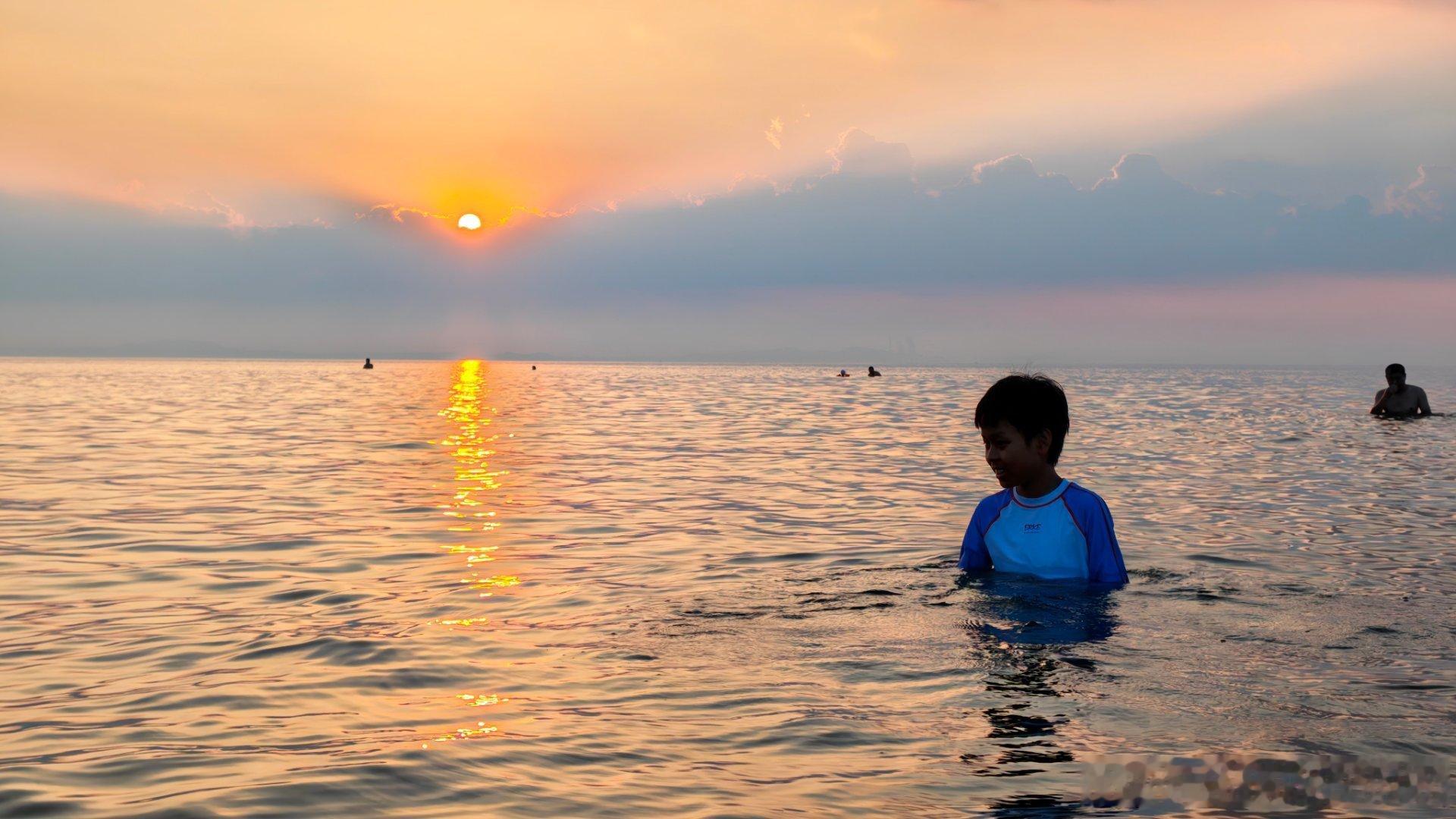刚才和我儿一起在海里见证了今天的日落。我们走到仅露出头的深度，一起看着太阳落到和