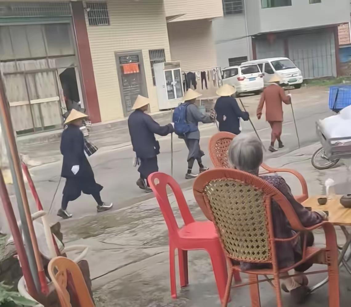 广东梅州街头惊现“神秘队伍”：头戴斗笠脚踩怪鞋，沉默列队吓坏路人，网友炸锅：这到