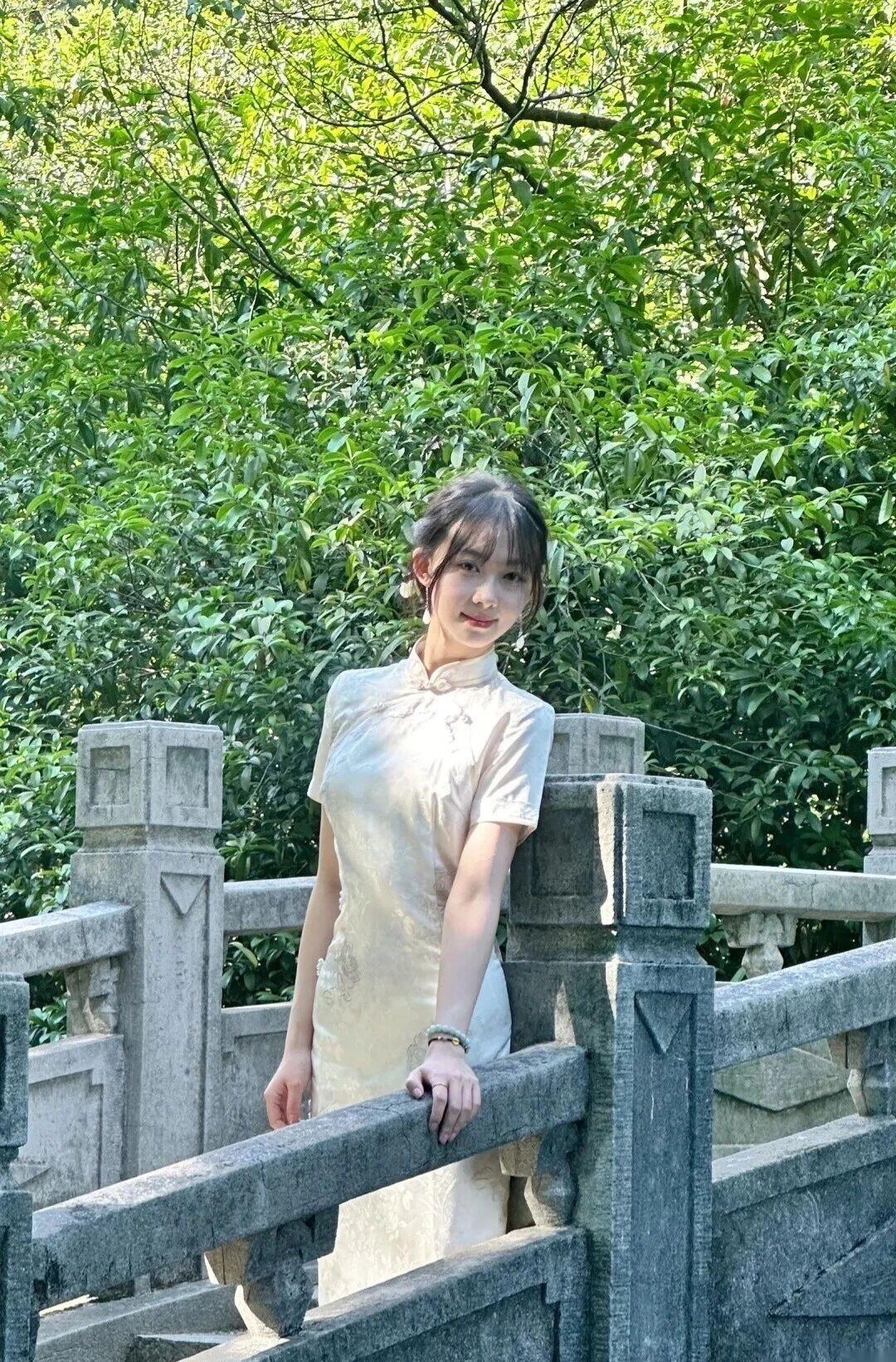 她的头发被精心盘起，鬓边点缀着精致的发饰，尽显古典韵味。面容清丽，肌肤白皙，眉眼