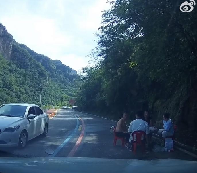四个成年人端坐马路上吃饭，吓得开车的网友一生冷汗。几个人成年人，毫无安全意识，把