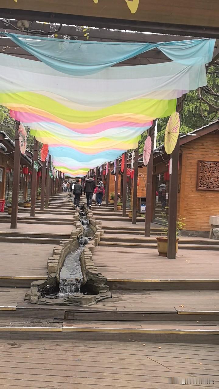 景区飘动的彩色丝绸挡不住景区门店的冷落。李白写诗的地方，金龙戏水......一个