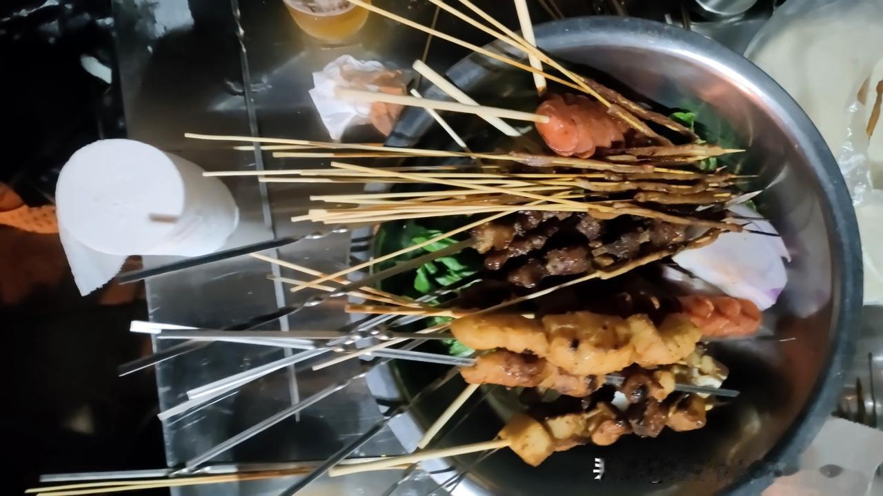 朋友买了肉要吃烧烤，我们大家动手，很快串好，出发到了有夜灯的小树林边烧烤。
男同