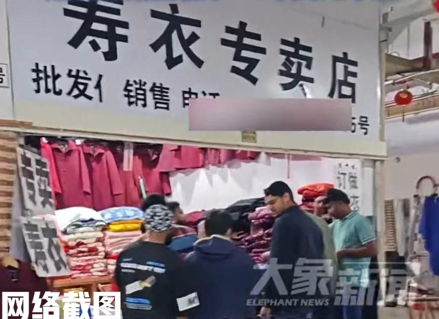 江苏镇江有老外旅游逛市场进寿衣店。

这群老外朋友一路走一路看，却被一家寿衣店所
