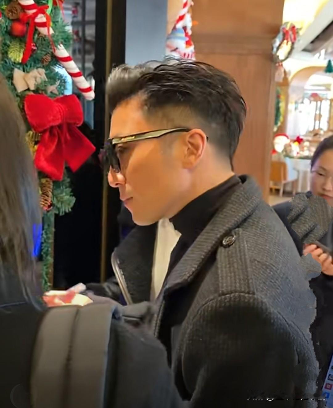 谢霆锋乘坐电梯被网友偶遇，他一身灰黑色毛呢风衣太帅了，内搭干净羊毛衫，戴着黑色墨