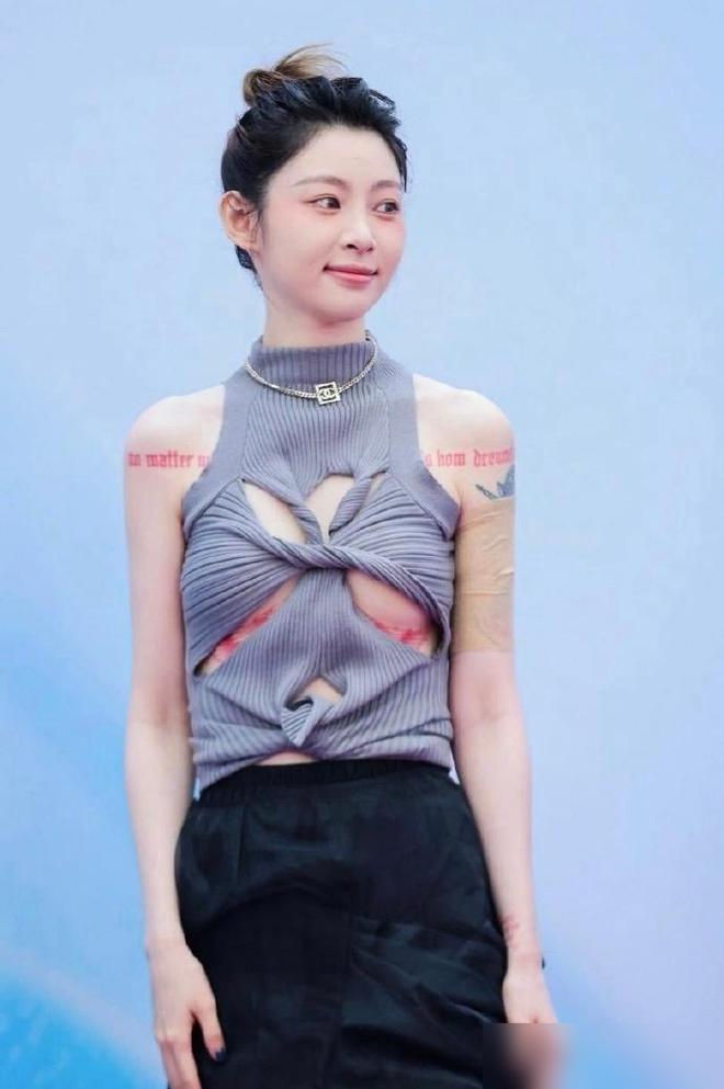 贴身背心硬生生剪出几个大洞，千万网红痞幼顶着镜头，把上围底下一整圈血红色的繁复刺