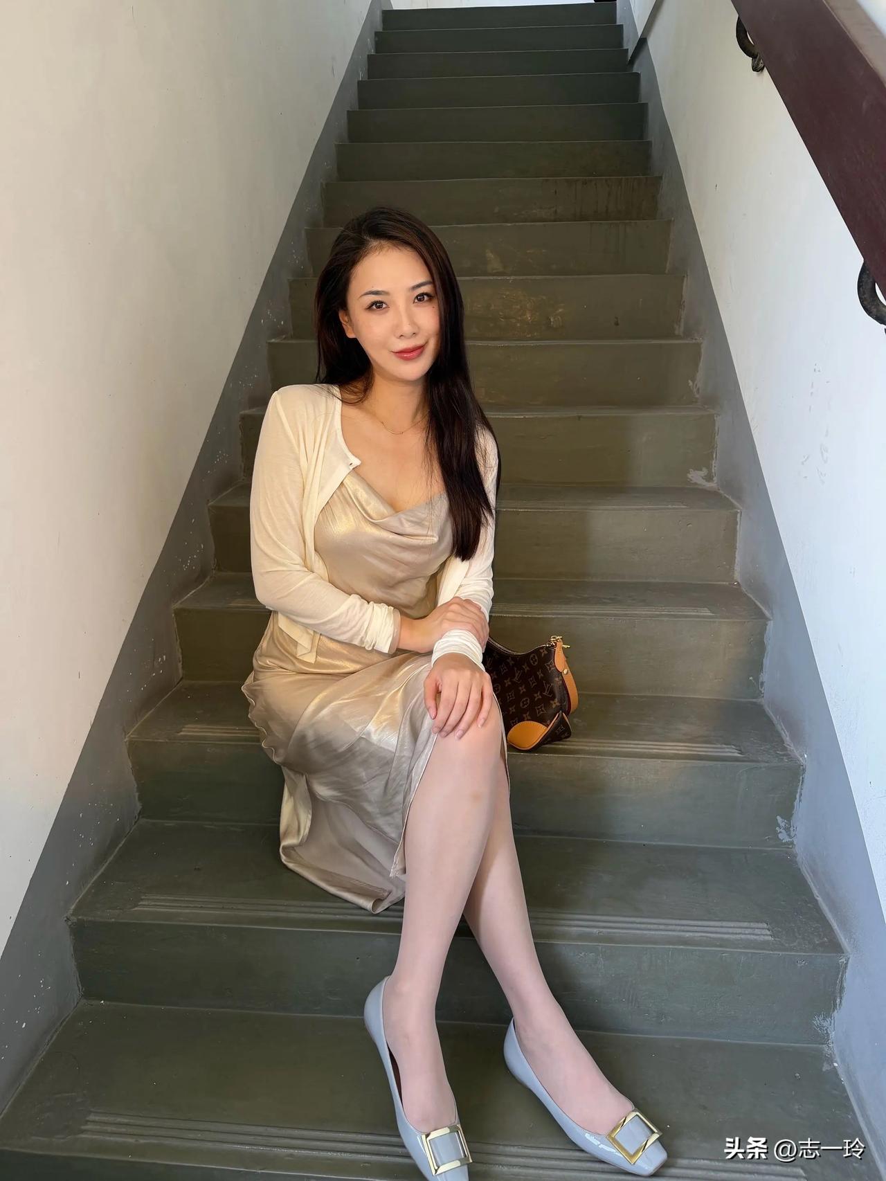 一个女孩坐在楼梯上，笑得很甜。