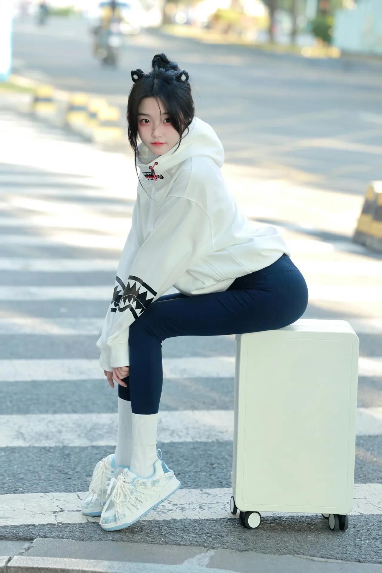 阳光刚好落在斑马线上，拖着行李箱的猫耳少女正把日常穿成元气穿搭～鲨鱼纹卫衣配紧身
