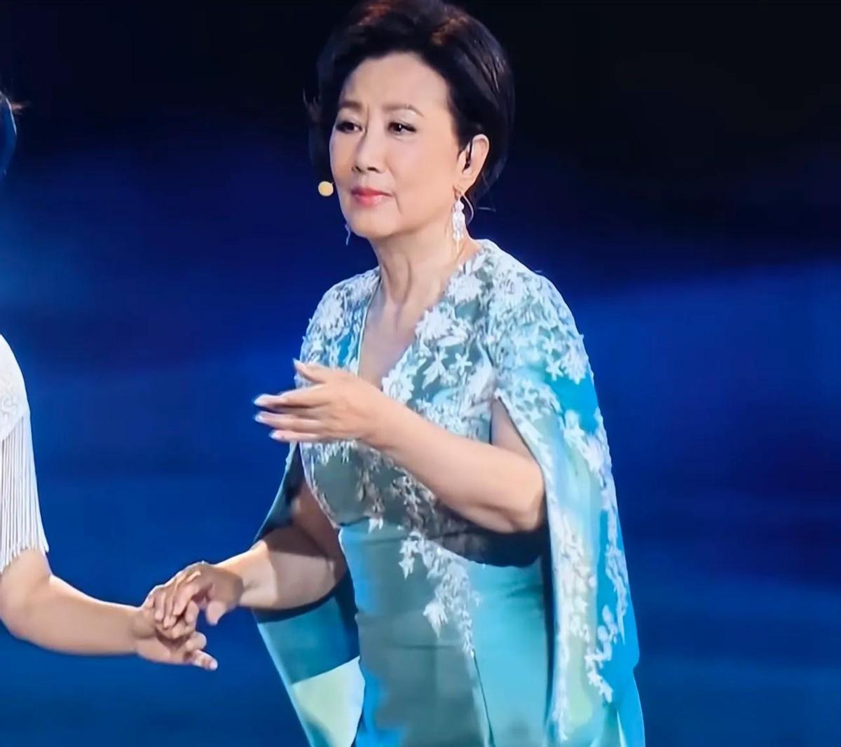 78岁汪明荃穿亮紫旗袍录节目，镜头一拉近，那头黑发厚得像假发，衬得脸比后台三十岁