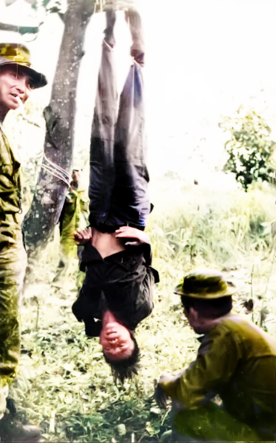1966年，越南。美国特种兵将一名自愿 “援越抗美”的中国年轻人倒挂在树上审讯。