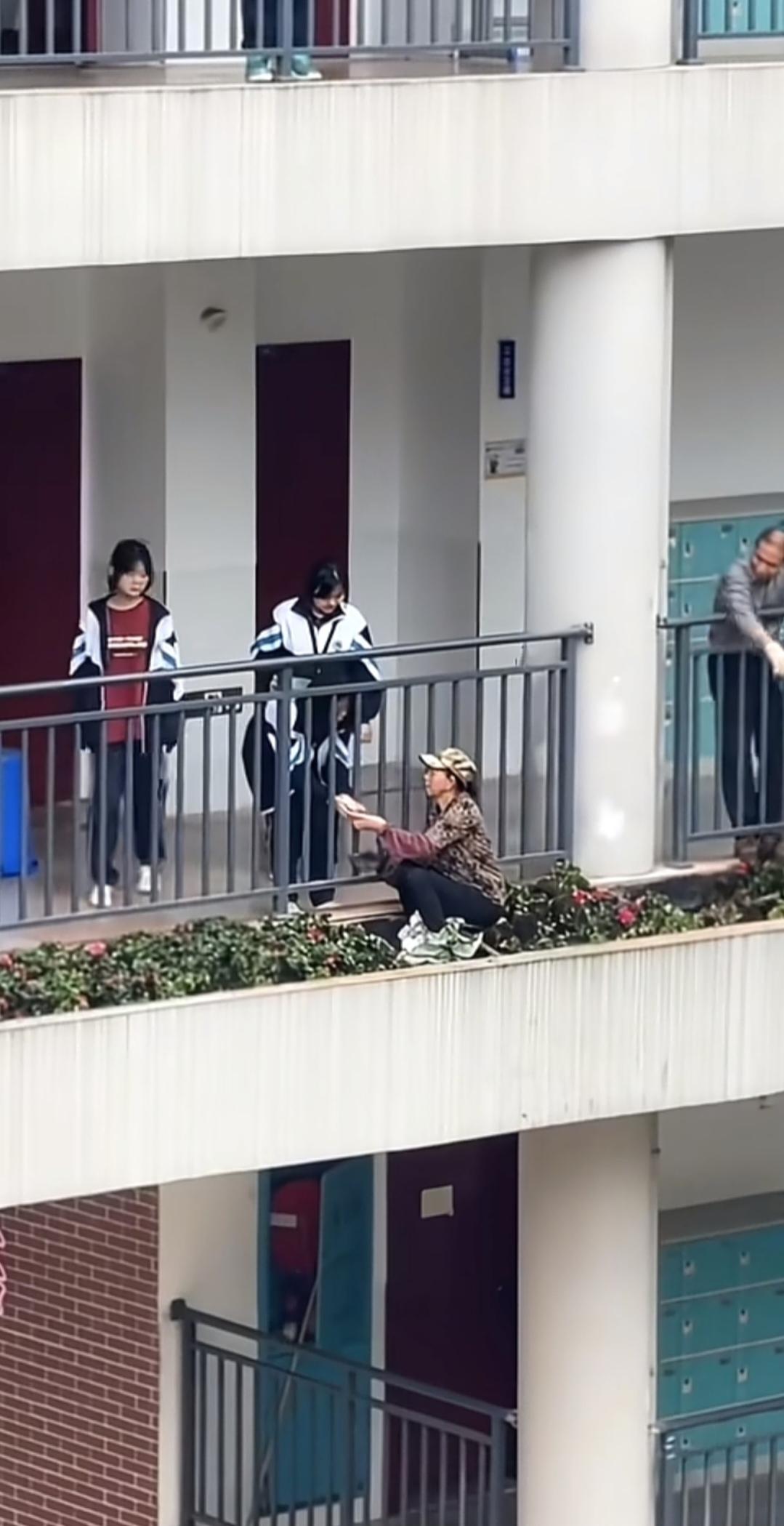 阳台边的花台上，一位农民工大姐正在干活，两名学生女孩的一个举动，让人直呼感动了。