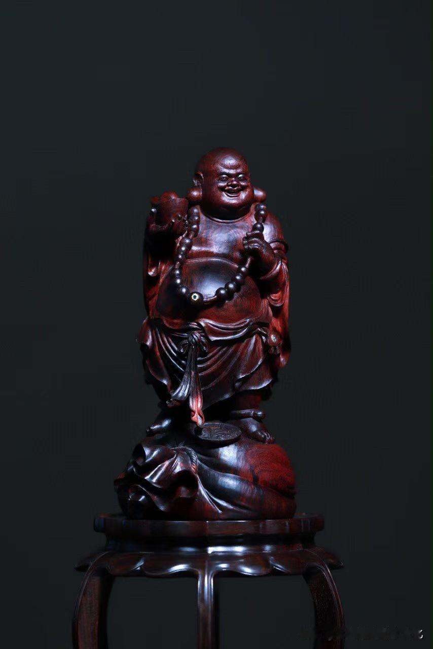 弥勒最耐看的，还是那一抹自然的笑意。

小叶紫檀色泽沉穆，弥勒踏布袋而立，身形敦