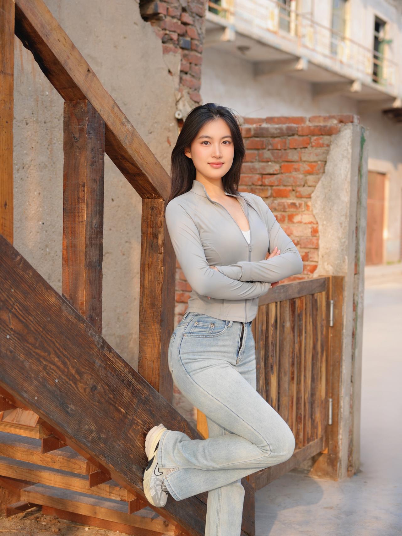 阳光下的少女，倚靠木梯，微笑如春