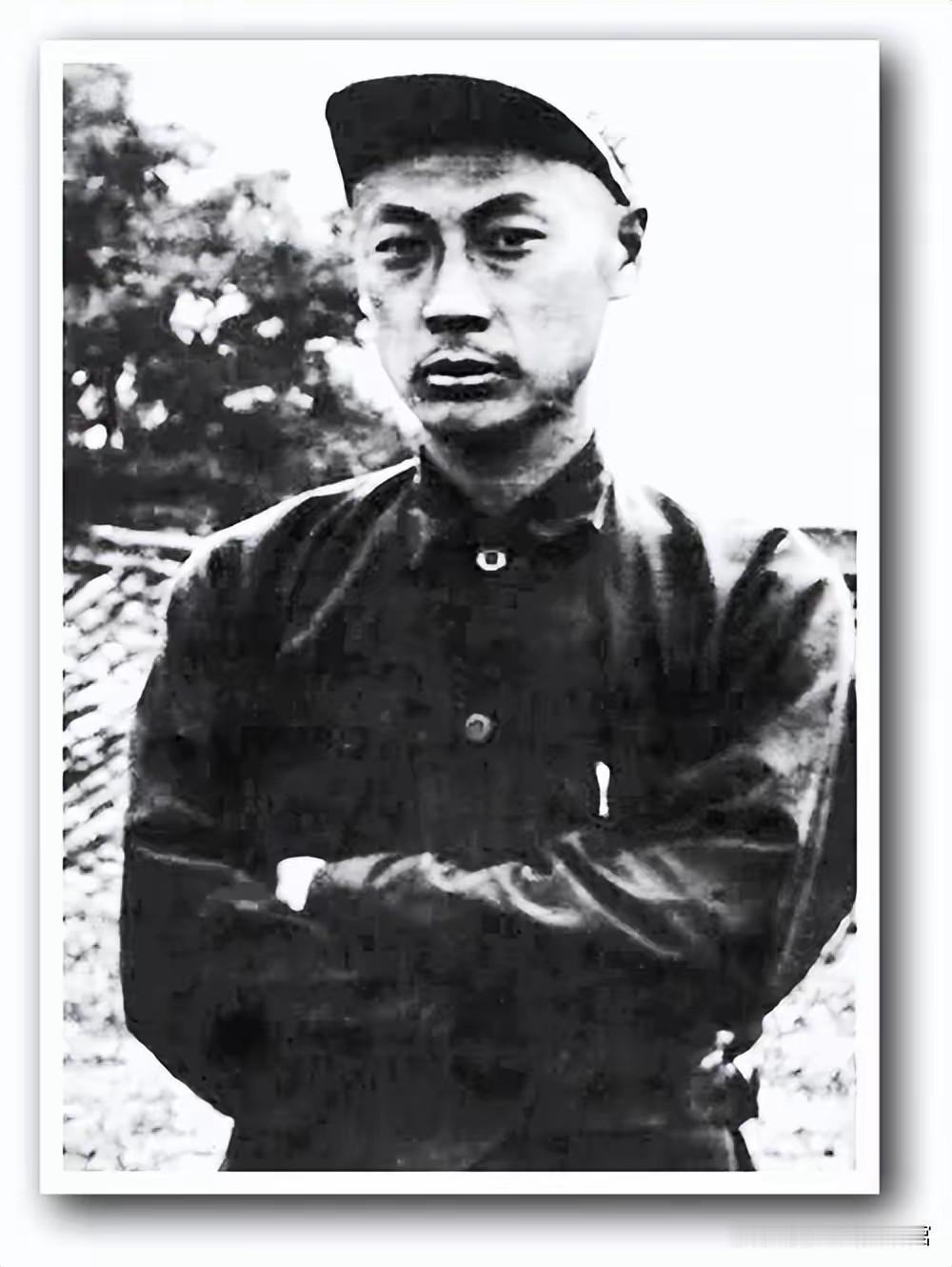 这张照片是青年时期的陈毅元帅，他身着朴素军装，头戴军帽，双臂交叉，目光坚毅沉稳。