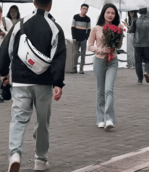 造孽呀！街上人来人往，一个姑娘怀里抱着一束玫瑰从远处走来，迎面碰到一个过路的小伙