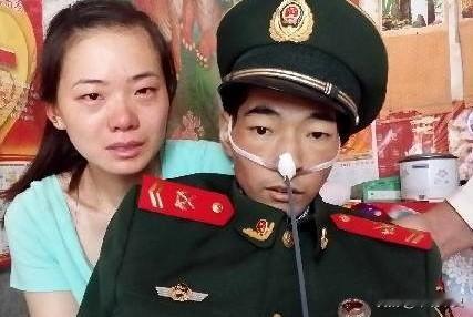 照片上的这个人身穿军装，骨瘦如柴，他此刻强打起精神，与妻子一起拍下了人生中最后的