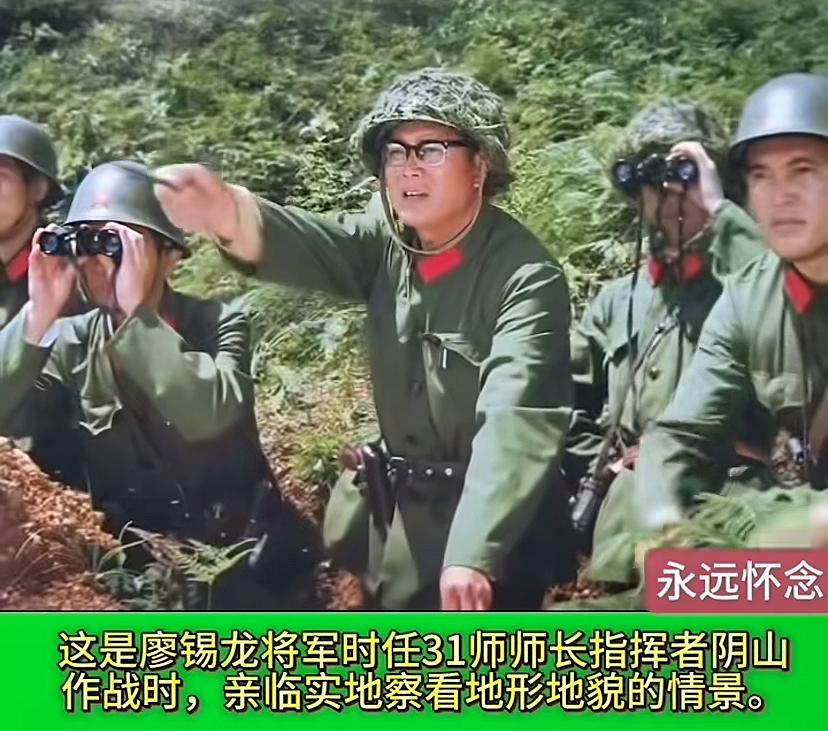 廖将军指挥打仗的镜头，穿着绿军装，两片红心肩上扛，上兜挎着笔，头上戴头盔，腰上扎
