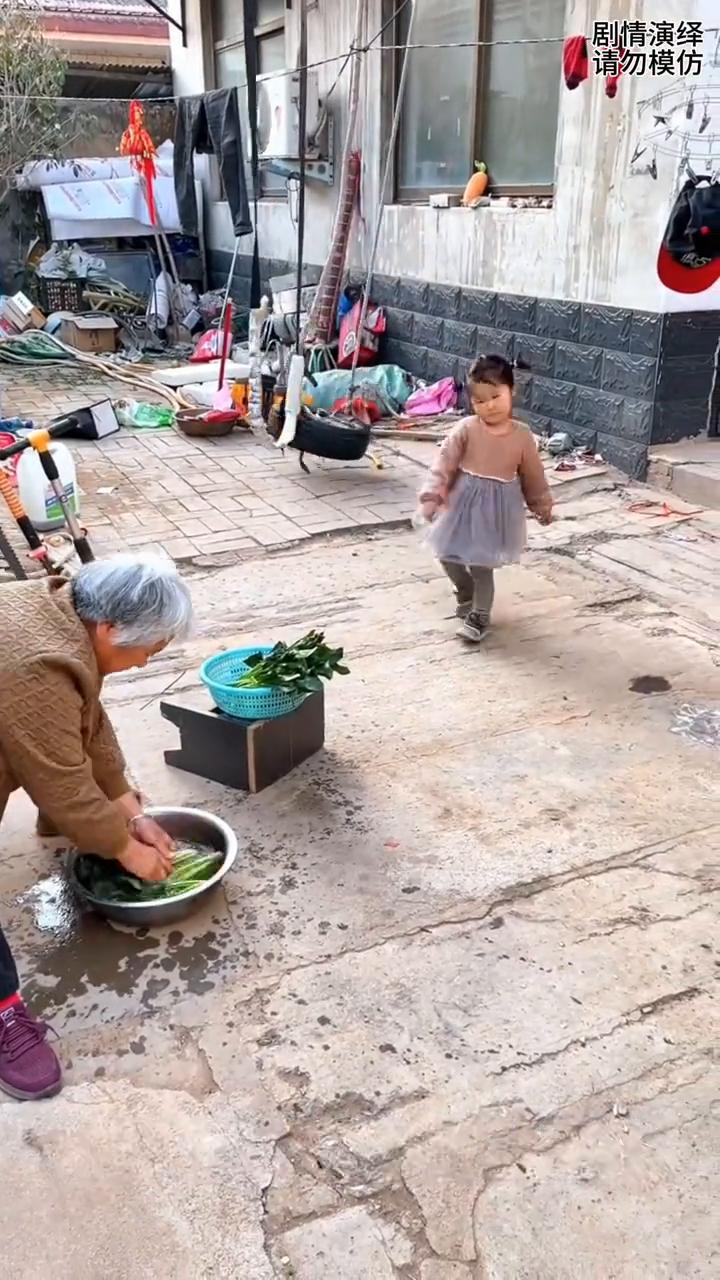 奶奶洗菜时孙女去捣乱，这一幕真的太有才了。
奶奶正在洗菜时，只见孙女从秋千上下来