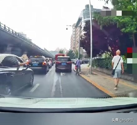 7月25日，辽宁大连，路口等红灯，一黑车副驾随手抛出一个矿泉水瓶子，险些砸到路边