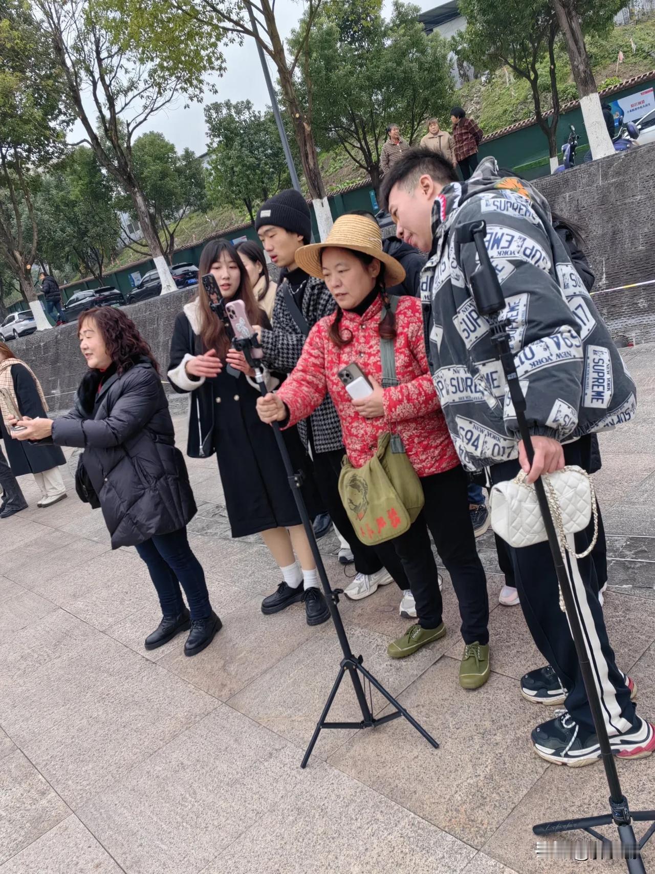 虽巳天寒地冻，万州区南山公园入处小广场，却因拍摄万州曼哈顿火爆得很，成了网红打卡