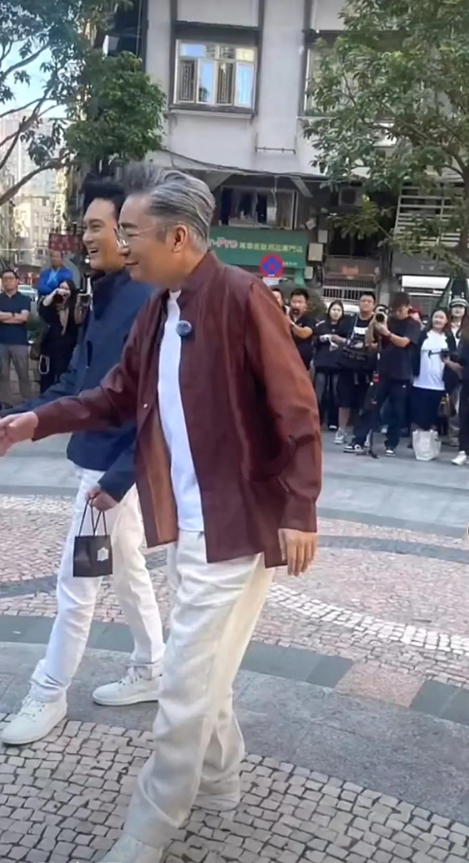 这位和张智霖走在澳门街头的白发眼镜男士是前央视主持人吧？花白的头发，古铜色休闲衬