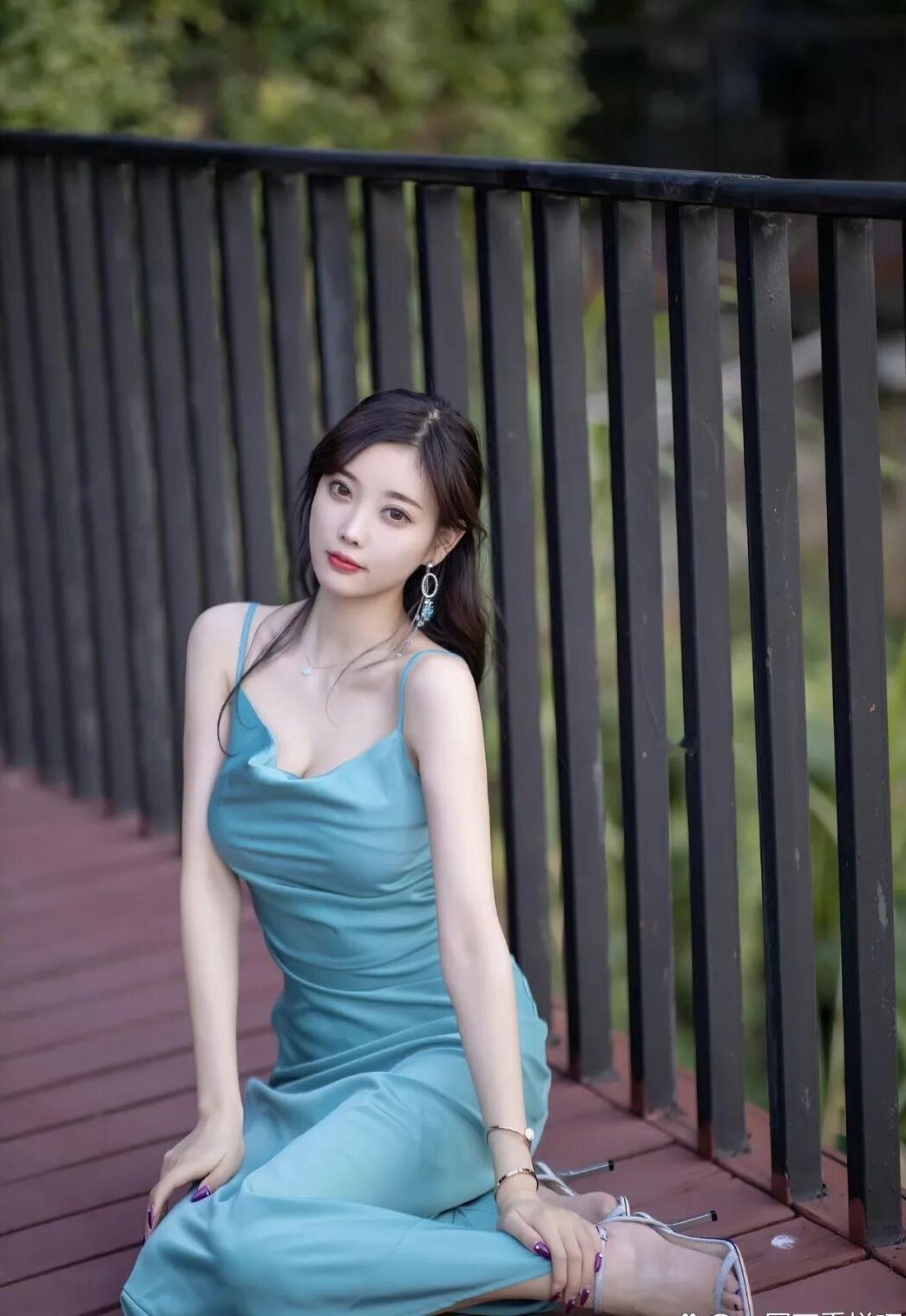 优雅蓝裙少女，静坐木桥边，享受宁静时光。