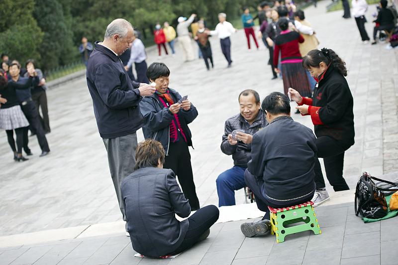 每到午后，小区楼下的超市门口，总固定着那么几位中年妇人凑在一处打扑克牌，五毛钱一