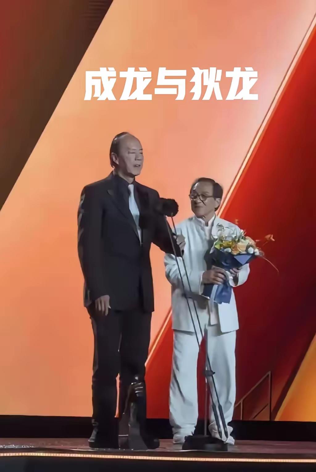 两个人在台上拿花讲话。大哥站在大哥面前也很可爱。[作揖][玫瑰]领奖姿势
