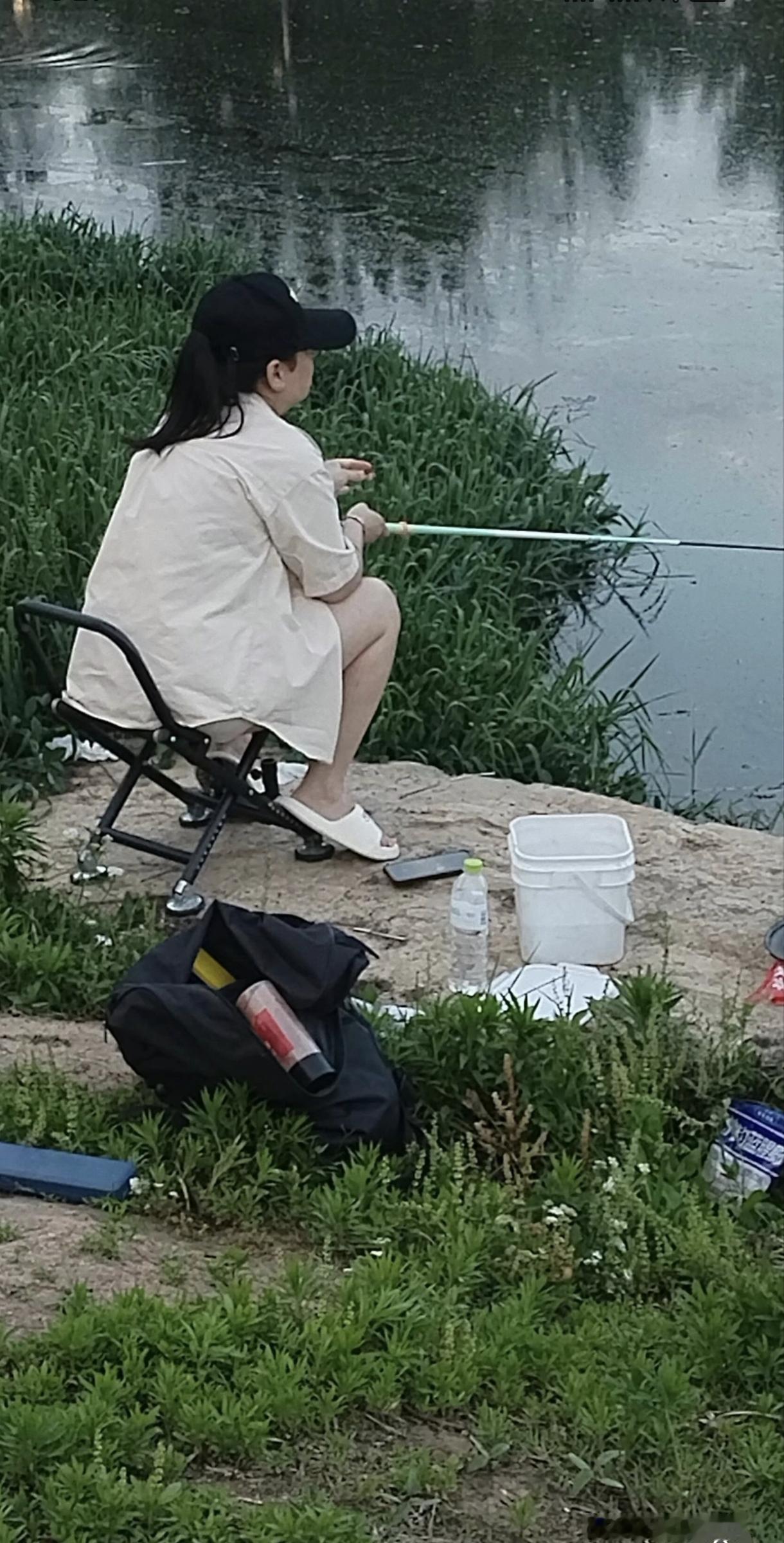 水面混浊，看着有点都漂油了。女钓友比较少见，皮肤白白净净的，可能偶尔钓一下。