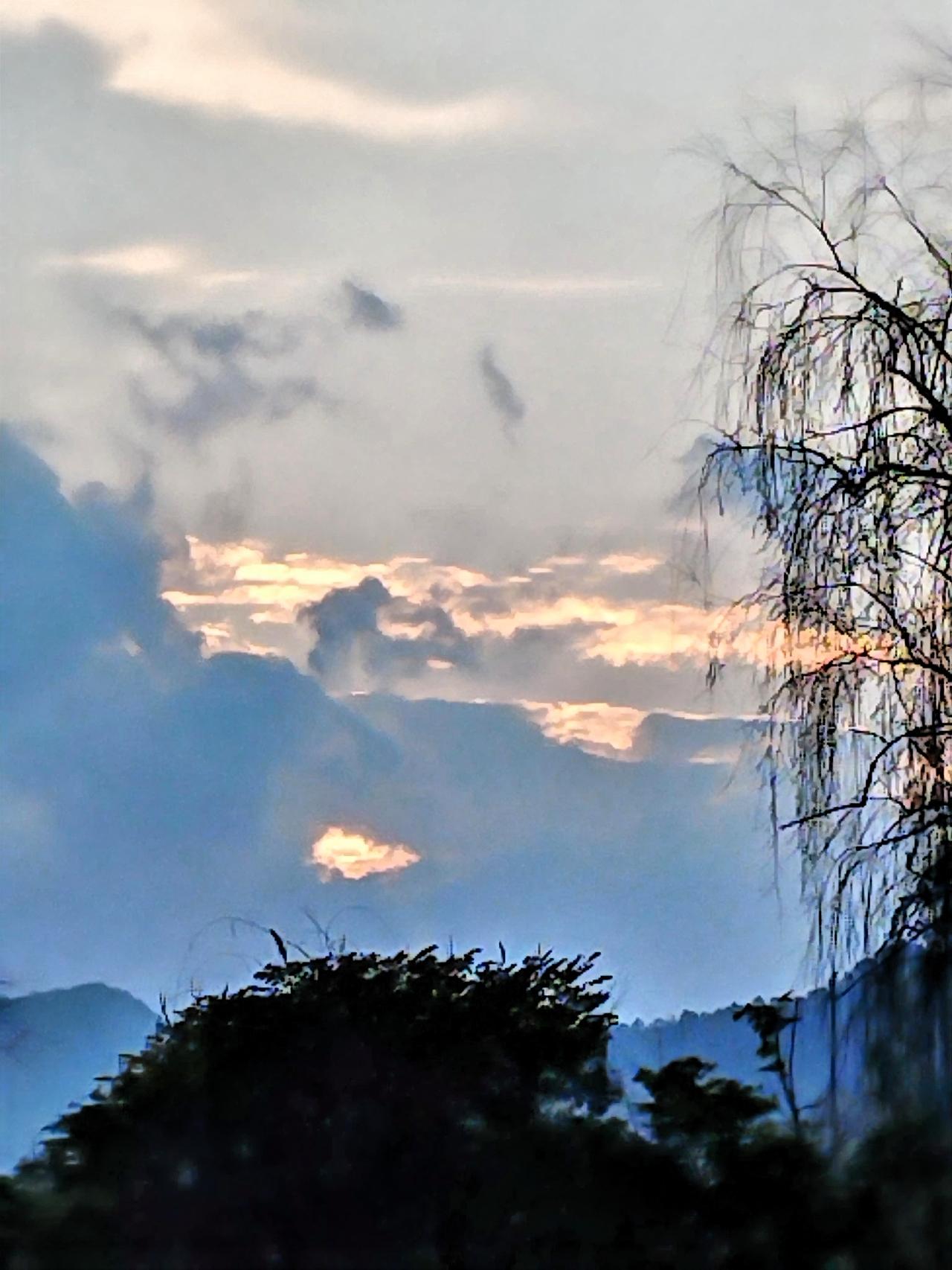 云层间透出夕阳的光芒，美不胜收。