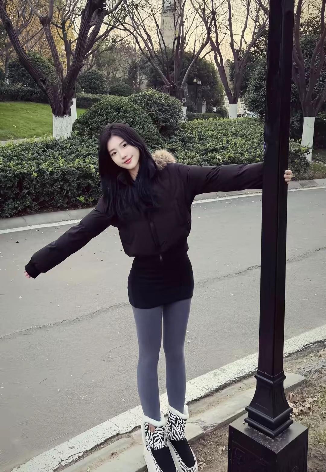 冬日暖阳下的时尚穿搭，黑衣少女与绿植的完美融合。