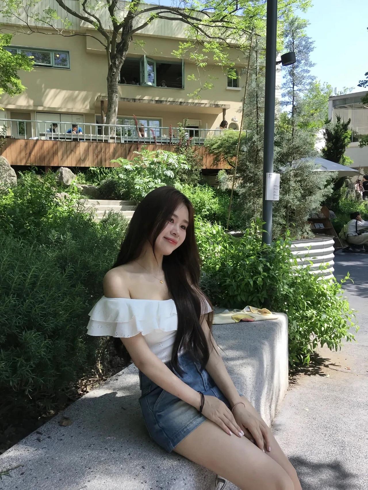 阳光下的甜美女孩，白色露肩上衣搭配牛仔短裤，轻松自在地享受美好时光。