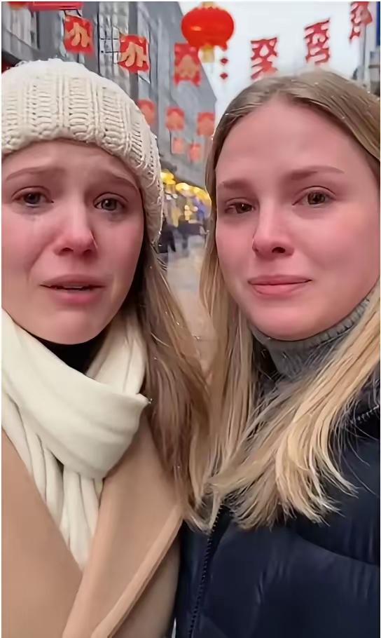 两个乌克兰姑娘站在街头，带着哭腔说着："战争让我们来到熊猫，家里人都没了..."