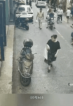 大街上车来人往，只见一位女子穿着得体，东瞅瞅，西看看，大步走到一辆电动车旁边，顺
