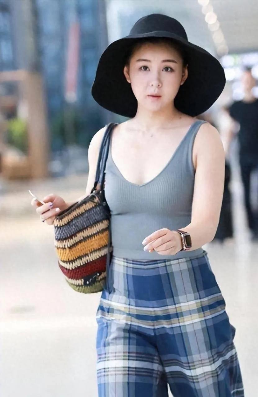 李小萌机场私服太有味道了！
灰色针织背心搭配蓝格阔腿长裤，简约随性。
修身背心勾