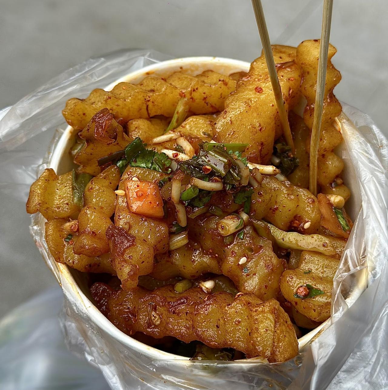 谁懂啊！街头偶遇的这碗锅巴土豆，直接把我香迷糊了。金黄焦脆的外皮裹满红油辣子，咬